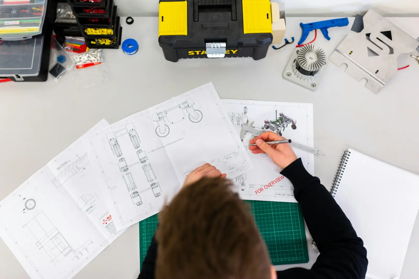 Engineer reviewing technical drawings and plans at a desk