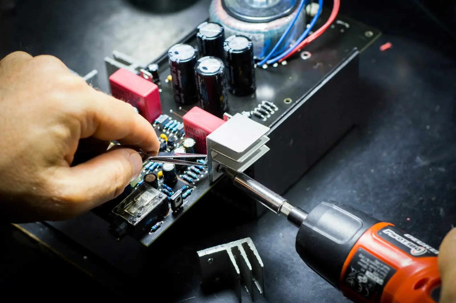 Technician assembling electronic hardware with a screwdriver